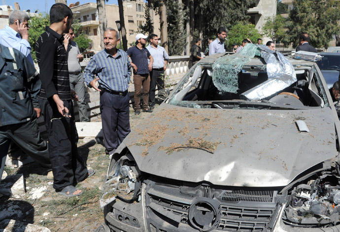 A handout picture released by the Syrian Arab News Agency (SANA) on April 29, 2013, shows people gathered at the scene of a blast in the Mazzeh district of Damascus. (AFP Photo/SANA)