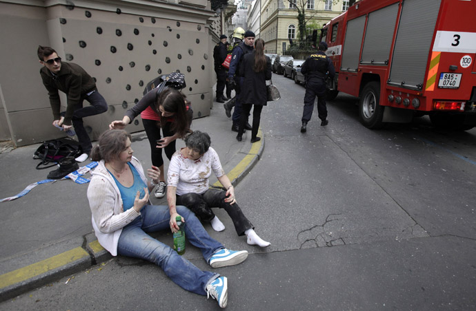 Injured people sit on a sidewalk near the area of a blast after an explosion in Prague April 29, 2013. (Reuters/David W Cerny)