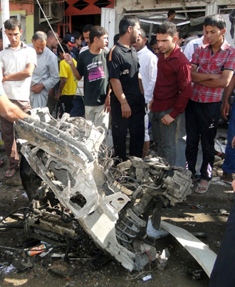 Iraqis inspect the site of a car bomb explosion in Diwaniyah, south of Baghdad, on April 29, 2013. (AFP Photo)