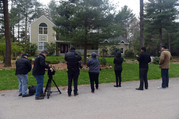 News media wait outside the home of Warren and Judith Russell, where their daughter Katherine Tsarnaeva, the widow of Tamerlan Tsarnaev, is staying, after flowers were placed there, on Coriander Lane April 23, 2013 in North Kingstown, Rhode Island. (AFP Photo / Darren Mccollester)