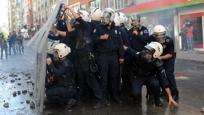 Police shelter behind their shields during clashes with protestors at a May Day demonstration on May 1, 2013, in Istanbul.(AFP Photo / Bulent Kilic)