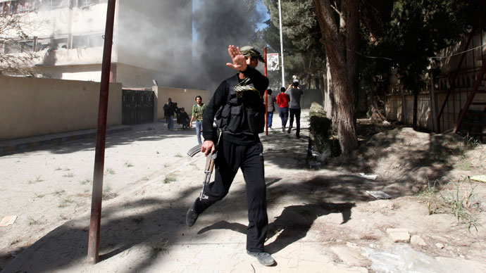 A fighter from the Islamist Syrian rebel group Jabhat al-Nusra reacts as a picture is taken of him as their base is shelled in Raqqa province, eastern Syria, March 14, 2013. (Reuters / Hamid Khatib)