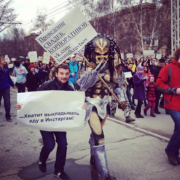The man in a Predator costume holds a sign saying: âOrganization of weddings, corporate partiesâ, with the other Monstration participant demanding: âStop posting food on Instagram!â (Image from instagram user@artemtiunov)