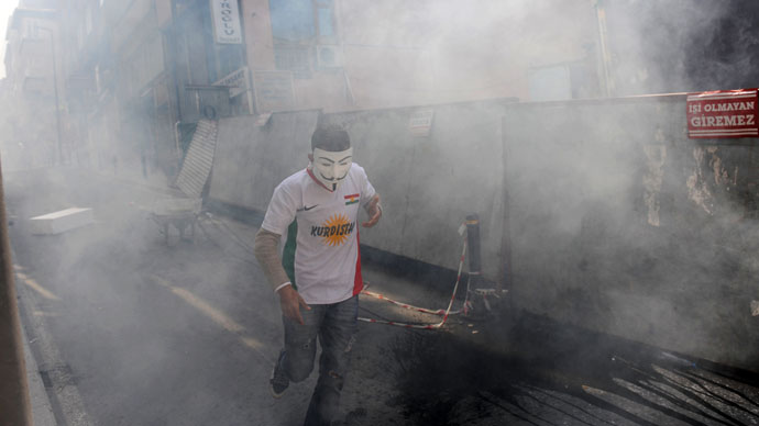 A protestor wearing a tee-shirt reading "Kurdistan" and a "Guy Fawkes" mask runs during clashes at a May Day demonstration on May 1, 2013 in Istanbul.(AFP Photo / Bulent Kilic)