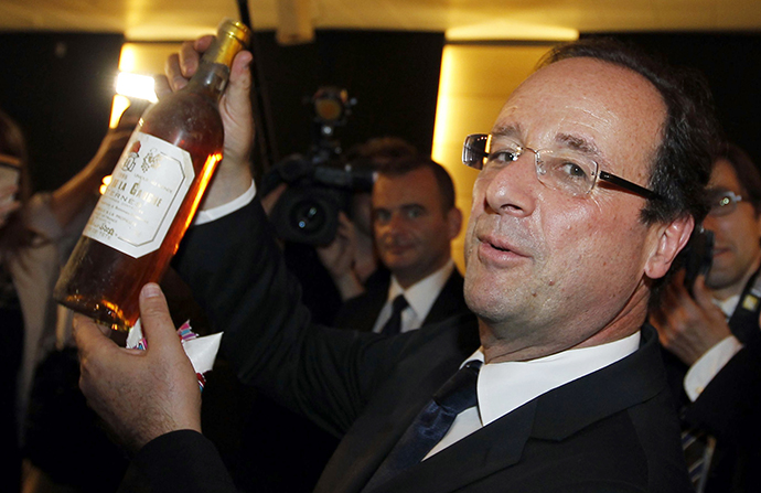 France's President Francois Hollande displays a bottle of wine he received during his visit to the General Council of Correze in Tulle, May 11, 2012. (Reuters / Regis Duvignau)