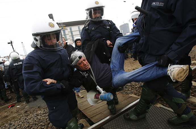 German riot police carry a left-wing protestor from the railway tracks as protestors block the tracks during a demonstration against a right-wing rally in Frankfurt, May 1, 2013. (Reuters / Kai Pfaffenbach)