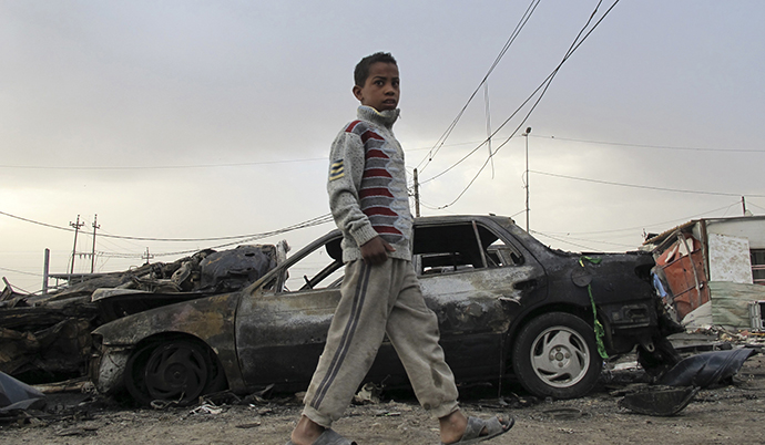 A boy walks near the site of a car bomb attack in al Habibya district in Baghdad April 16, 2013. (Reuters / Saad Shalash)