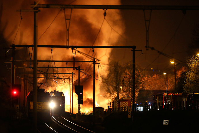 Firemen work next to a train on fire on a track near Schellebelle, 20 kms east of Gent on May 4, 2013 (AFP Photo / Belga / Nicolas Maeterlinck)