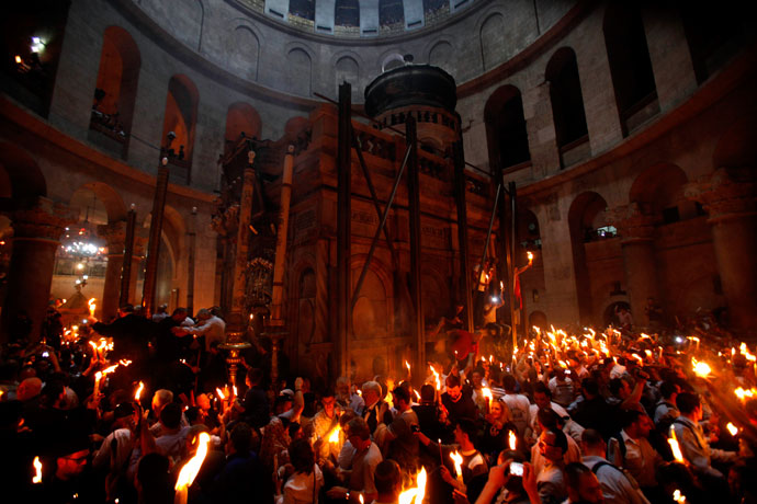 Christian Orthodox worshippers hold up candles lit from the 'Holy Fire' as thousands gather in the Church of the Holy Sepulchre in Jerusalem's old city on May 4, 2013.(AFP Photo / Gali Tibbon)