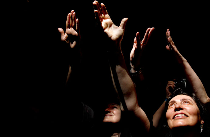 Christian Orthodox worshippers hold their hands up as a ray of light comes through a skylight in the Church of the Holy Sepulchre in Jerusalem's old city on May 4, 2013.(AFP Photo / Gali Tibbon)