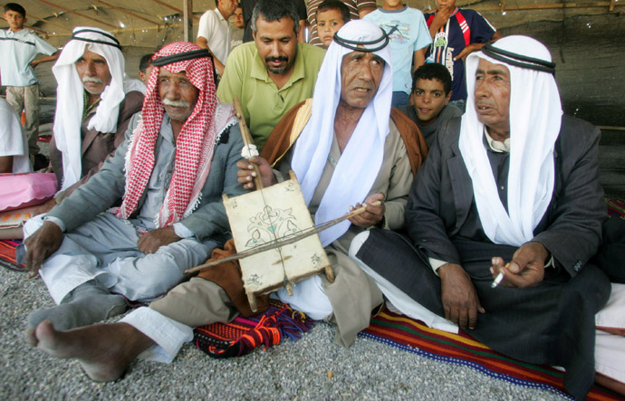 Bedouin men sit together during wedding celebrations in the village of Kusaifa in Israel's Negev desert (Reuters)