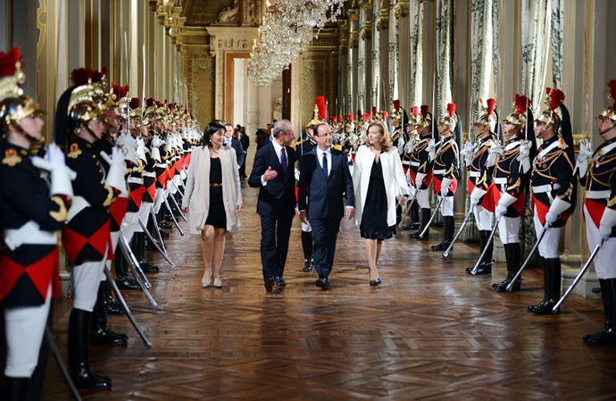 French president Francois Hollande flanked by his partner Valerie Trierweiler, Paris' mayor Bertrand Delanoe (2ndL) and Paris' deputy mayor Anne Hidalgo arrives to deliver a speech as part of a ceremony held at Paris' town hall following his investiture, on May 15, 2012 in Paris. (AFP Photo / Philippe Desmazes)
