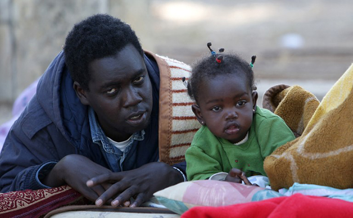 Sudanese refugees wake up at a park near the Israeli Parliament building in Jerusalem. (AFP Photo / Yoav Lemmer)