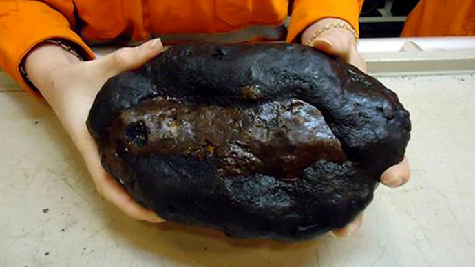 Member showing one of the rocks digged out from the deep-sea during dredging works, 1,500 km far from the shore of Rio de Janeiro.(AFP Photo / HO)