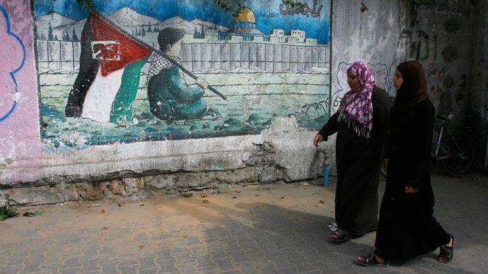 Palestinian women walk past a mural on the theme of return of refugees to their land in what is now Israel in the southern Gaza Strip refugee camp of Rafah on May 8, 2012.(AFP Photo / Said Khatib)