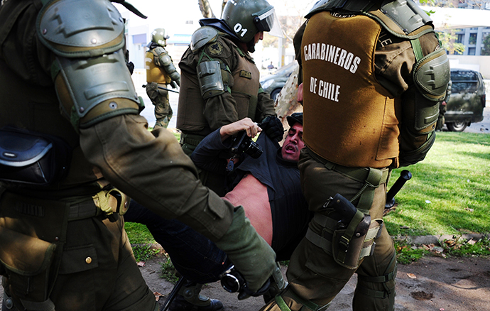 Riot policemen arrest a photographer during a student protest to demand Chilean President Sebastian Pinera's government to improve the public education quality, in Santiago, on May 08,2013. (AFP Photo / Martin Bernetti)