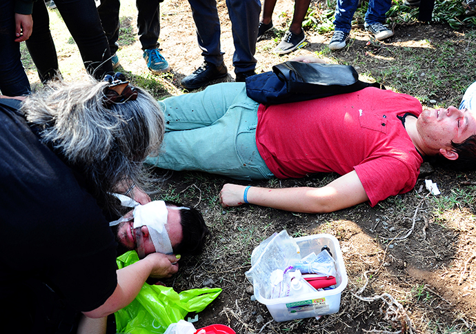 A press photographer receives medical attention after being injured during a student protest to demand Chilean President Sebastian Pinera's government to improve the public education quality, in Santiago, on May 08,2013. (AFP Photo / Martin Bernetti)
