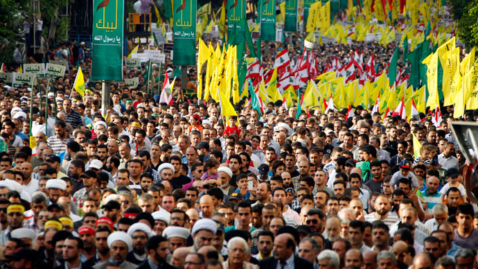Supporters of Lebanon's Hezbollah leader Sayyed Hassan Nasrallah wave Hezbollah and Lebanese flags as they march at an anti-U.S. protest in Beirut's southern suburbs September 17, 2012.(Reuters / Sharif Karim)