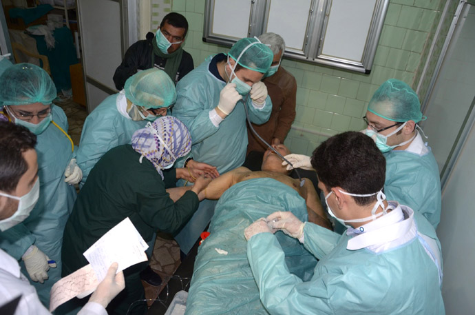  In this image made available by the Syrian News Agency (SANA) on March 19, 2013, medics and other masked people attend to a man at a hospital in Khan al-Assal in the northern Aleppo province, as Syria's government accused rebel forces of using chemical weapons for the first time. (AFP/SANA)
