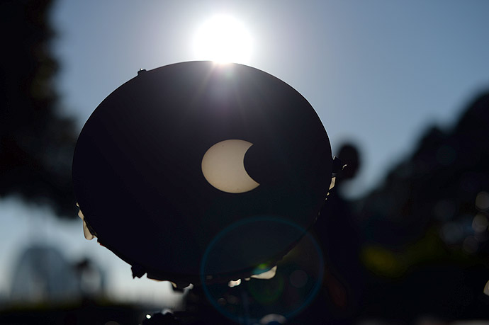 A focused image onto a white background through a telescope shows the moon crossing in front of the sun as seen from the Sydney Observatory on May 10, 2013. (AFP Photo/Saeed Khan)