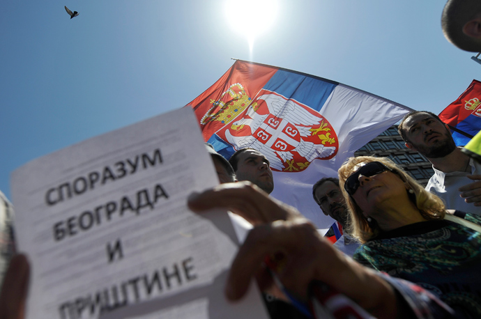 A demonstrator reads a paper reading "Brussels accord between Belgrade and Pristina" during a protest against the accord on the normalisation of relations between Serbia and Kosovo in the Serbian capital Belgrade on May 10, 2013 (AFP Photo / Andrey Isakovic)