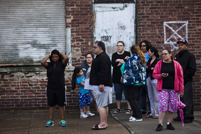 People look on at members of the police (not pictured) during a hostage situation in Trenton, New Jersey, May 11, 2013. 