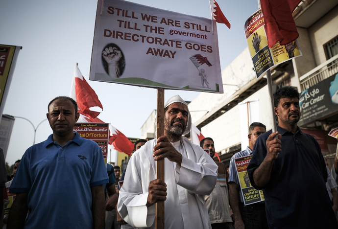 Bahraini protestors hold up placards during an anti-government protest in the village of Jidhafs, west of Manama, on May 10, 2013 (AFP Photo / Mohammed Al-Shaikh)