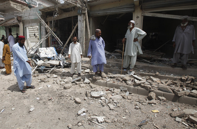 Residents gather at the site of a bomb attack near a polling station during an election, in Karachi May 11, 2013. (Reuters)