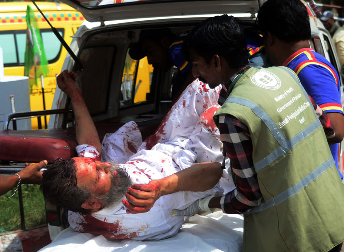 Pakistani volunteers shift an injured blast victim to a hospital following a bomb explosion in Karachi on May 11, 2013. (AFP Photo)