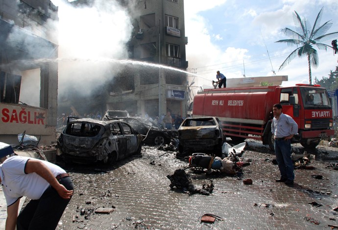 People stand on the site of a car bomb explosion on May 11, 2013 near the town hall of Reyhanli (AFP Photo / Ihlas News Agency)