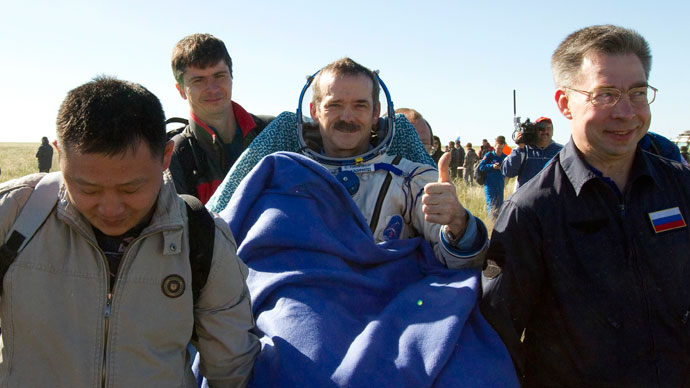 Ground personnel carry Canadian astronaut Chris Hadfield (C) after the Russian Soyuz space capsule landed some 150 km (90 miles) southeast of the town of Zhezkazgan, in central Kazakhstan May 14, 2013.(Reuters / Sergei Remezov)