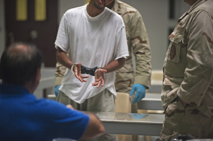 In this photo reviewed by US military officials, a detainee inside Camp VI is put in transport restraints to be taken back to his cell after after attending a life skills class that includes resume writing inside the US military detention center in Guantanamo Bay, Cuba (AFP Photo / Paul J. Richards)