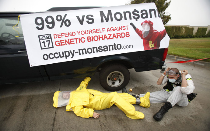 Protesters against Genetically Modified Organisms (GMO) are chained to a vehicle as they block a delivery entrance to a Monsanto seed distribution facility in Oxnard, California September 12, 2012. (Reuters/Mario Anzuoni)