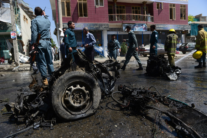 Afghan policemen walk around the destroyed suicide car bomb at the site of a suicide attack in Kabul on May 16, 2013. (AFP Photo)