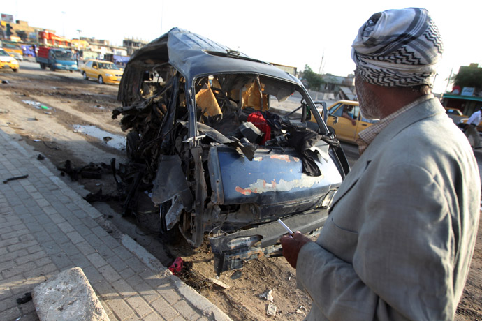 An Iraqi man looks at the remains of a vehicle at the scene of a car bomb explosion the previous days in Baghdad's Sadr City district on May 16, 2013. (AFP Photo)