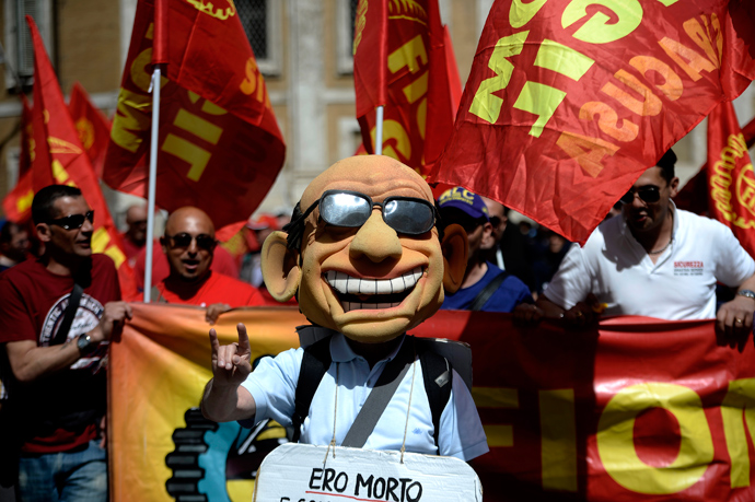 A man wearing a mask resembling former Prime Minister Silvio Berlusconi demonstrates during the left-wing Italian metalworkers' union FIOM rally in downtown Rome on May 18, 2013 (AFP Photo / Filippo Monteforte)