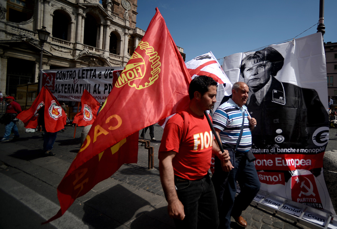 Demonstrators walk pass a banner showing German Chancellor Angela Merkel dressed as a Nazi during the left-wing Italian metalworkers' union FIOM rally in downtown Rome on May 18, 2013 (AFP Photo / Filippo Monteforte)