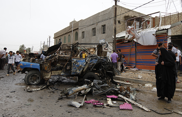 Residents gather at the site of a car bomb attack in the Kamaliya district in Baghdad May 20, 2013. (Reuters / Mohammed Ameen)