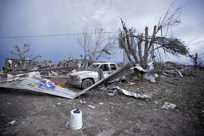 Piles of debris and cars lie around a home destroyed by a tornado May 21, 2013 in Moore, Oklahoma. (AFP Photo / Brett Deering)