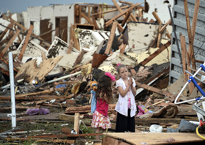 Two girls stand in rubble after a tornado struck Moore, Oklahoma, May 20, 2013. (Reuters / Gene Blevins)
