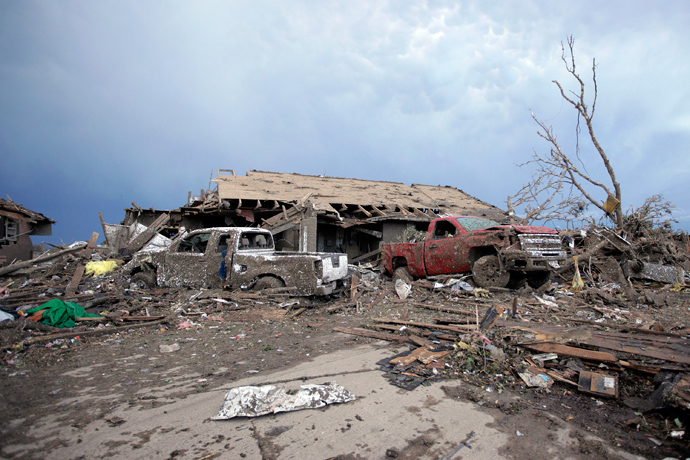 Piles of debris and cars lie around a home destroyed by a tornado May 21, 2013 in Moore, Oklahoma (Brett Deering / Getty Images / AFP) 