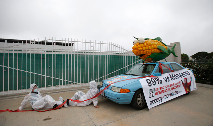 Protesters against Genetically Modified Organisms (GMO) are chained to a vehicle as they block a delivery entrance to a Monsanto seed distribution facility in Oxnard, California (Reuters / Mario Anzuoni)