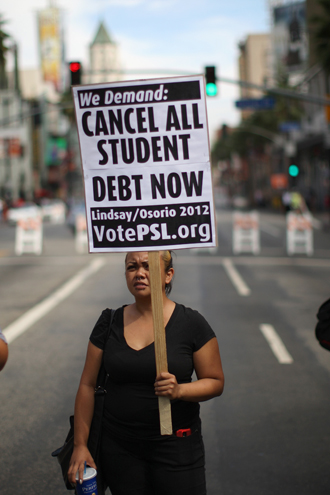 A woman holds a placard on Hollywood Boulevard while protesting the rising costs of student loans for higher education on September 22, 2012. (AFP Photo / David Mcnew)