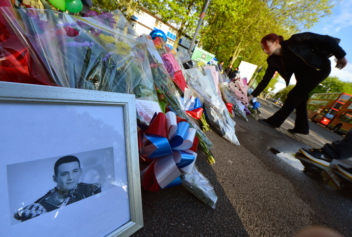 A picture of victim Drummer Lee Rigby, of the British Army's 2nd Battalion The Royal Regiment of Fusiliers is displayed with flowers left by mourners outside an army barracks near the scene of his killing in Woolwich, southeast London May 23, 2013 (Reuters / Toby Melville)