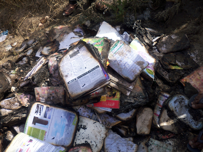 Burnt schoolbooks are seen near a school bus, on which a gas cylinder exploded, killing seventeen children, on the outskirts of Gujrat, 100 miles (170 km) southeast of Islamabad, May 25, 2013 (Reuters / Stringer)