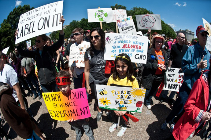 People hold signs during a demonstration against agribusiness giant Monsanto and genetically modified organisms (GMO) in front of the White House in Washington on May 25, 2013. (AFP Photo / Nicholas Kamm)