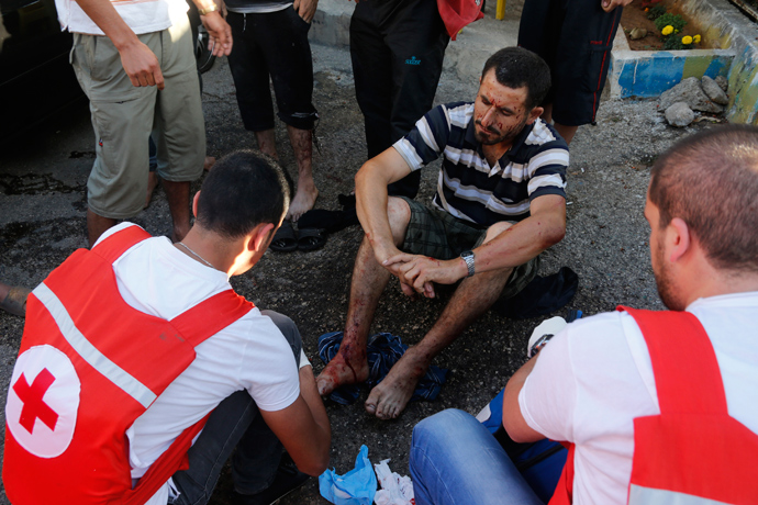 Members of Lebanese Red Cross treat a wounded man after two rockets hit his house in Beirut suburbs May 26, 2013 (Reuters / Mohammed Azakir)