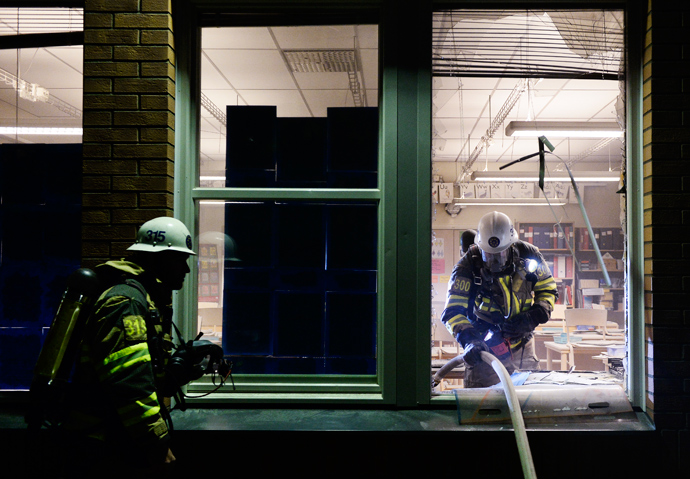Firemen extinguish a burning school room in the Stockholm suburb of Tensta after youths rioted in few different suburbs around Stockholm and Sweden on May 25, 2013 (AFP Photo)