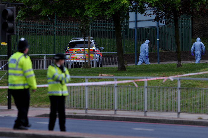Police forensics officers search a cordoned off area in Woolwich, east London, on May 22, 2013, following an incident in which one man was killed and two others seruiously injured (AFP Photo / Carl Court)