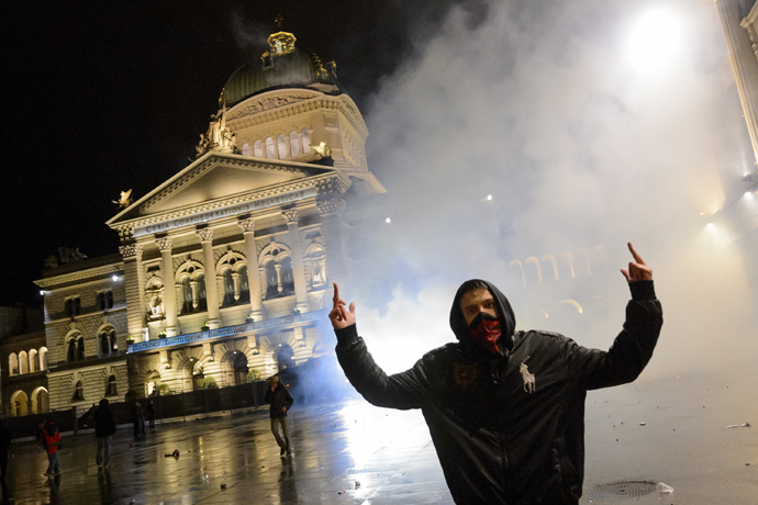 A man reacts after the riot police flooded with tear gas in front of the Swiss House of Parliament on late May 25, 2013 in the center of Switzerland's capital Bern during the 3rd edition of "Tanz Dich Frei" (Dance Yourself Free) a politically-tinged techno parade and mass unauthorised rally (AFP Photo / Fabrice Coffrini)